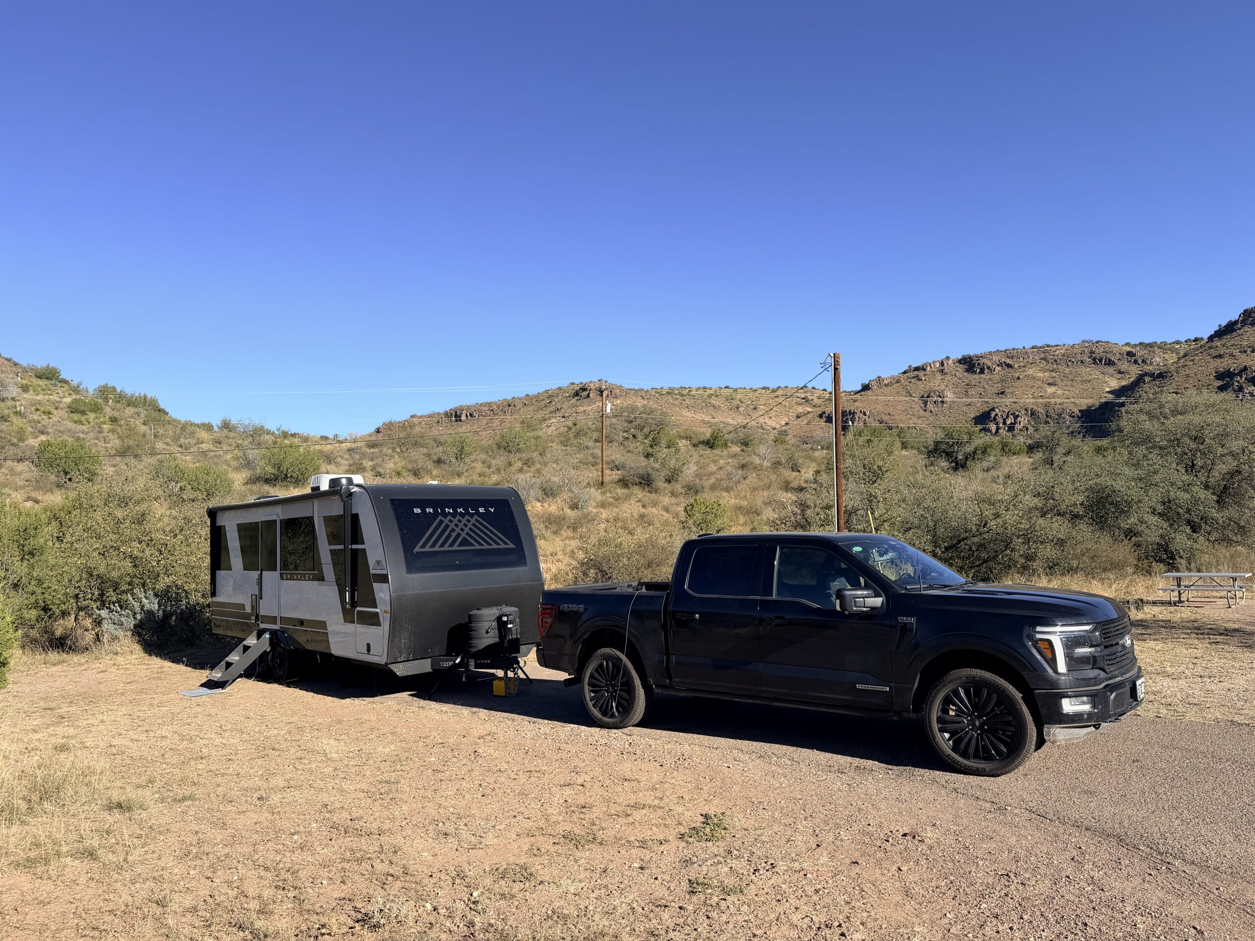 The Brinkley trailer and black pickup at a dry hillside campsite in the Davis Mountains, Texas.