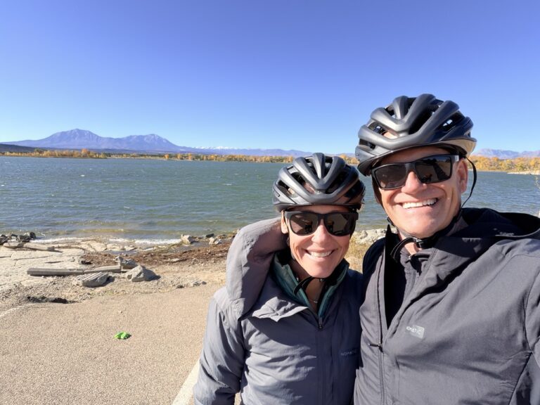 Erin and Matt in bike helmets on a lakeshore